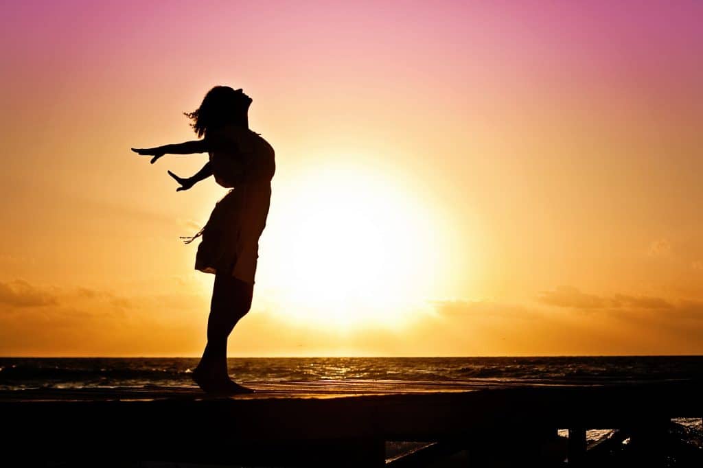 Mulher em frente a um pôr do sol